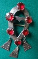 Silver brooch with red crystals and pendants